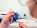 Profissional da saúde com vacina em suas mãos