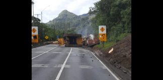 Carreta tomba com retroescavadeira e bloqueia BR-376, em Guaratuba