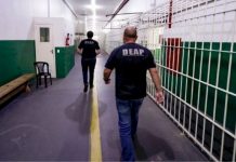 Funcionários caminhando dentro de complexo penitenciário