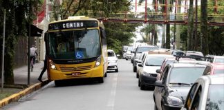 Avenida de Joinville com ônibus em parada junto ao fluxo de carros