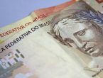 Duas notas de dinheiro, em papel, das quantias de 50 reais e 20 reais