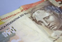 Duas notas de dinheiro, em papel, das quantias de 50 reais e 20 reais