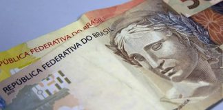 Duas notas de dinheiro, em papel, das quantias de 50 reais e 20 reais