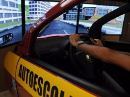 janela de carro de autoescola com duas mãos segurando o volante