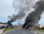 rodovia bloqueada com objetos pegando fogo