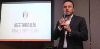 Darthanhan Oliveira com um microfone na mão enquanto fala em reunião sobre o JEC