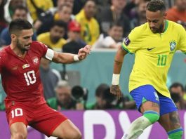 foto com dois jogadores um de uniforme vermelho e outro é o Neymar com o uniforme da seleção