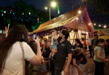 família tirando foto na praça com decorações de natal para ilustrar as inscrições abertas para o comércio ambulante de natal em Joinville