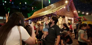 família tirando foto na praça com decorações de natal para ilustrar as inscrições abertas para o comércio ambulante de natal em Joinville