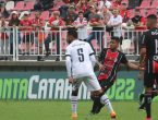 Atleta do JEC faz passe com a bola. Camisa 5 do Figueirense e camisa 19 do Joinville observam a bola.