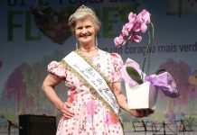 senhora segurando uma orquídea e sorrindo na festa das flores joinville