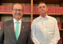 Governador eleito de Santa Catarina à esquerda e presidente Jair Bolsonaro à direita. Os dois estão em frente a uma estante com livros vermelhos.