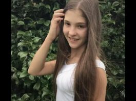 adolescente vítima de acidente em sc, de cabelos compridos, olha para foto e sorri, usa uma blusa branca e está com a mão no cabelo