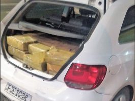 porta-malas de um carro branco aberto com fardos de maconha dentro