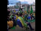 manifestantes sentados na rua, com cadeiras de pria e no asfalto, com bandeiras do brasil