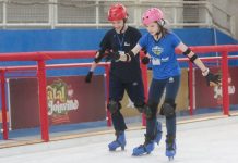 duas pessoas patinando na pista de patinação que faz parte das atrações de natal em joinville