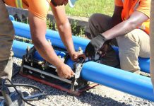 Paranaguamirim, em Joinville, terá abastecimento de água comprometido; confira ruas afetadas homens trabalhando em um duto azul representando obras que fazem ocorrer a falta de água no paranaguamirim em Joinville