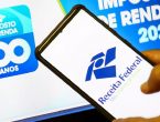 mão segurando um celular, na tela se vê escrito receita federal. Imagem ilustrativa para notícia sobre consulta do lote residual do imposte de renda