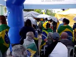 sob chuva, manifestantes de verde e amarelo protestam em joinville