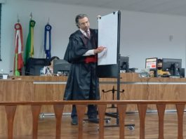 homem em pé em tribunal apontado em um quadro branco