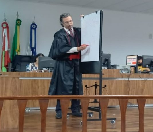 homem em pé em tribunal apontado em um quadro branco