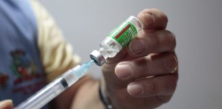 mão segurando uma vacina. vacinação covid-19 em joinville