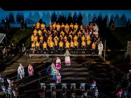 Hospital Infantil recebe musical natalino em Joinville; saiba quando atores em pé, em um palco, durante uma apresentação