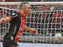 Ex-ala do JEC Futsal Caio comemora gol usando uniforme principal (vermelho, preto e branco)