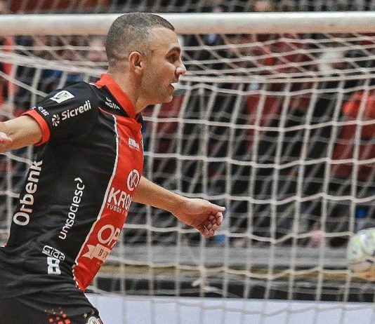 Ex-ala do JEC Futsal Caio comemora gol usando uniforme principal (vermelho, preto e branco)