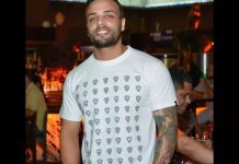 Homem usando camiseta branca e sorrindo