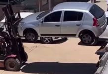 Sandero, um dos carros estacionados em locais proibidos, sendo removido por empilhadeira