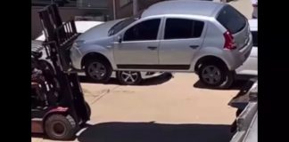 Sandero, um dos carros estacionados em locais proibidos, sendo removido por empilhadeira