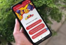Mão segurando celular com o aplicativo da Trimania Norte Joinville aberto
