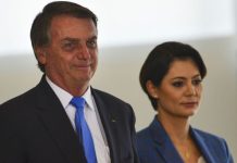 O ex-presidente Jair Bolsonaro sorri acompanha de sua esposa Michelle Bolsonaro